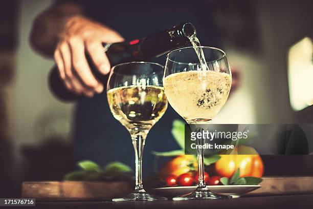 mann gießen sekt - champagner gläser mit flasche unscharfer hintergrund stock-fotos und bilder