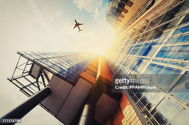 wolkenkratzer mit einer flugzeug-silhouette - airline industry stock-fotos und bilder