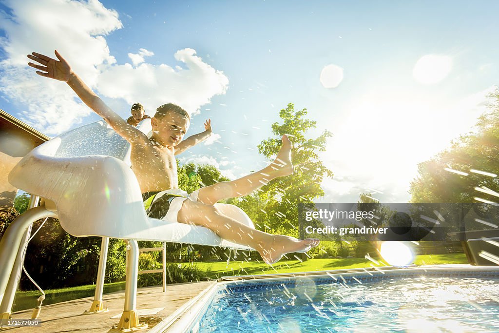 Jungen auf Swimmingpool und Wasserrutsche