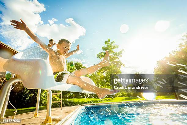 boys on swimming pool slide - waterslide bildbanksfoton och bilder