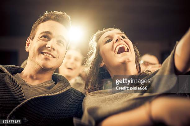 couple laughing at the cinema, watching comic movie - amour 2012 film stock pictures, royalty-free photos & images