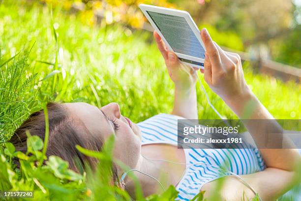 teenage girl portrait with e-reader outdoors in summer park - ereader stock pictures, royalty-free photos & images