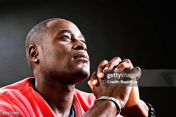 man offers up heartful prayer, hands clasped - preacher stock pictures, royalty-free photos & images