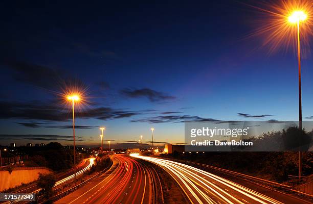 rush hour on motorway with blurred headlights at dusk - motorway uk stock pictures, royalty-free photos & images