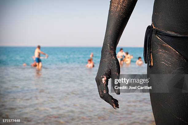 muddy hand covered in dried mud at the dead sea - people covered in mud stock pictures, royalty-free photos & images