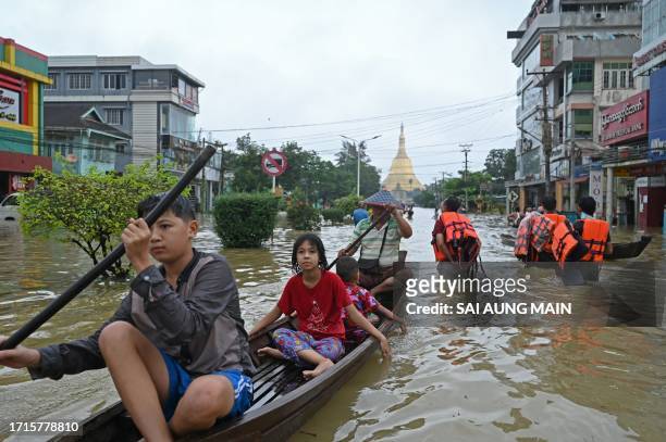 Local residents make their way through a flooded street after heavy rains in Bago township in Myanmar's Bago region on October 9, 2023. / "The...