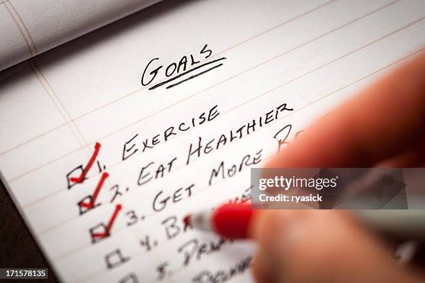 hand holding red marking pen checking off list of goals - tick list stock pictures, royalty-free photos & images