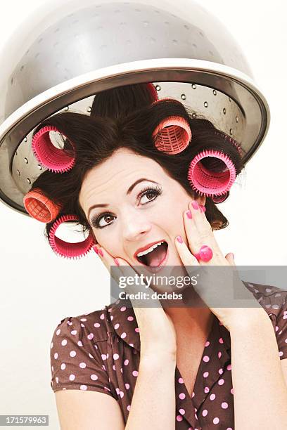 retro-styled young woman in curlers under salon hairdryer - hair curlers stockfoto's en -beelden