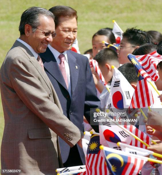 South Korean President Kim Dae-jung and visiting Malaysian Prime Minister Mahathir Mohamad shakes hands to welcome chirdren at the Blue House on 23...