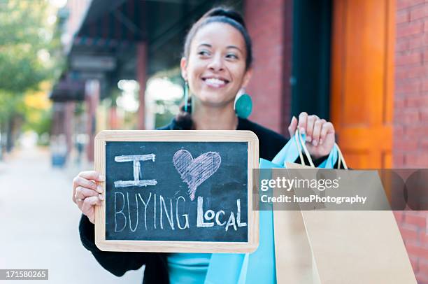woman holding sign that says i love buying local - duurzaam consumeren stockfoto's en -beelden