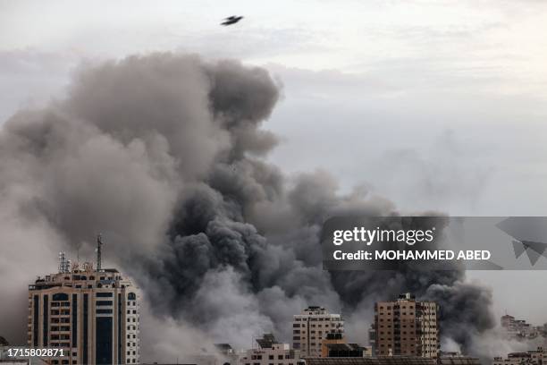 Smoke billows behind highrise buildings during an Israeli airstrike on Gaza City on October 9, 2023. Israel relentlessly pounded the Gaza Strip...