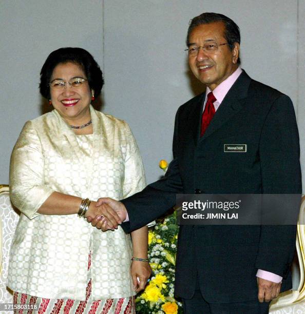 Indonesian President Megawati Sukarnoputri shakes hands with Malaysian Prime Minister Mahathir Mohamad prior to bilateral talks in Kuching, in the...