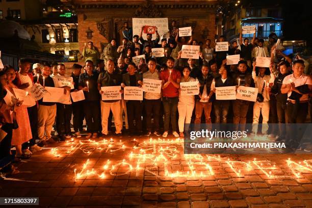 Students take part in a candlelight vigil in Lalitpur on October 9 in memory of Nepali citizens who were killed in Kibbutz Alumim, one of the...