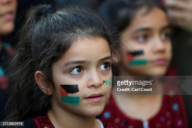 Young girls with face make-up on showing the Palestinian flag take part in a demonstration in support of Palestine at the Israeli Embassy on October...