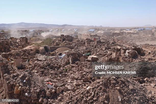 Afghan volunteers clear the debris of damaged village houses after a series of earthquakes in Zendeh Jan district of Herat province on October 9,...