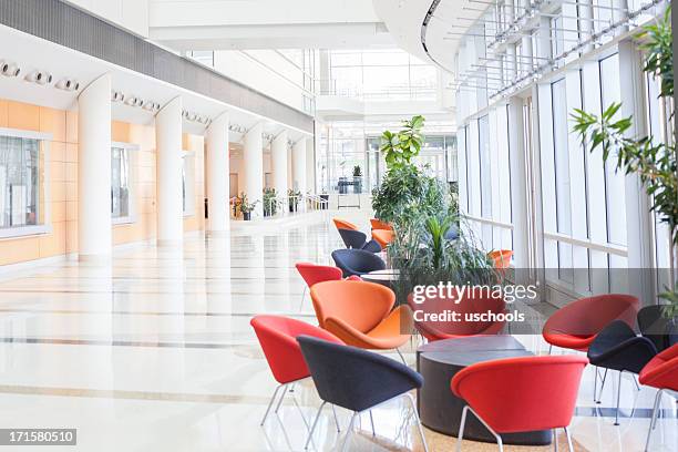 modern office lobby with colorful seats - building atrium stock pictures, royalty-free photos & images