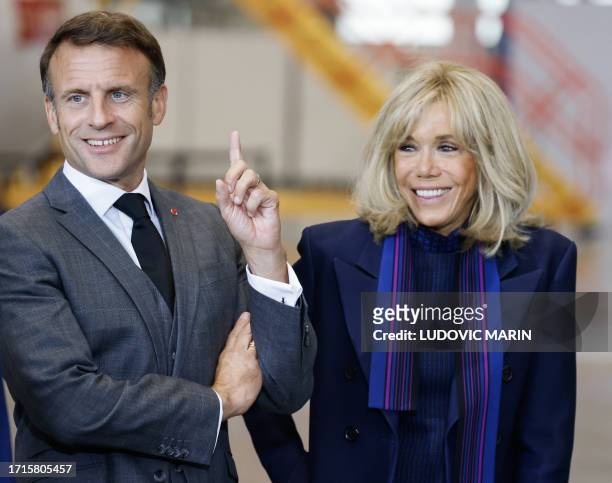 French President Emmanuel Macron and his wife Brigitte Macron smile during their visit of the Airbus plant in Hamburg, northern Germany, on October 9...