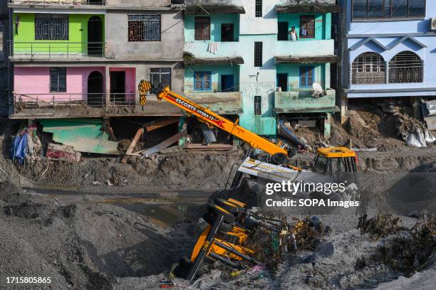 Vehicles lie in the debris of damaged houses in the flood affected area along the Teesta river. After a glacial lake in northeast India burst through...