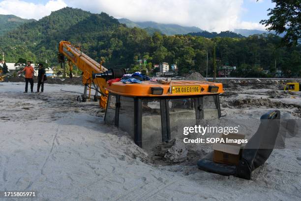 Construction vehicle is seen covered in debris caused by flash floods after a lake burst. After a glacial lake in northeast India burst through a dam...