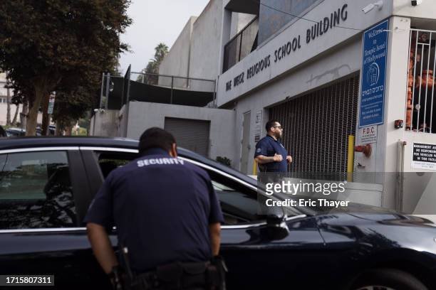 Security guards stand watch in front of a synagogue on October 9, 2023 in Los Angeles, California. Security is being increased at synagogues after...