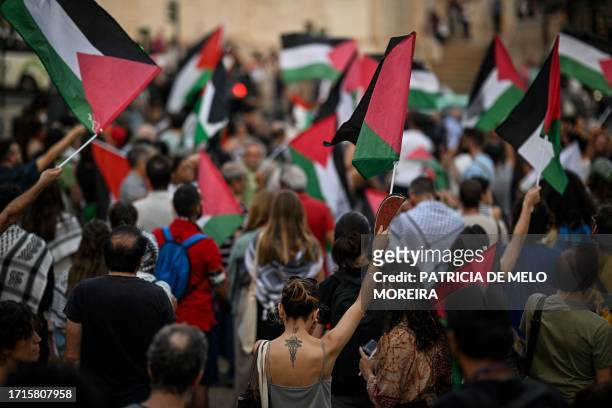 Protestors wave Palestinian flags during a rally in support of Palestinians at Camoes square in Lisbon on October 9, 2023 after the Palestinian...