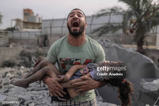 Palestinian man holds the dead body of his cousin that he pulled from the rubble after Israeli airstrikes in Gaza City, Gaza on October 09, 2023....