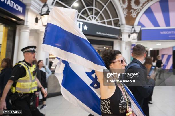 Police officers take security measures as people, carrying Israeli flags, show up during the pro-Palestinian demonstration in front of the Israeli...