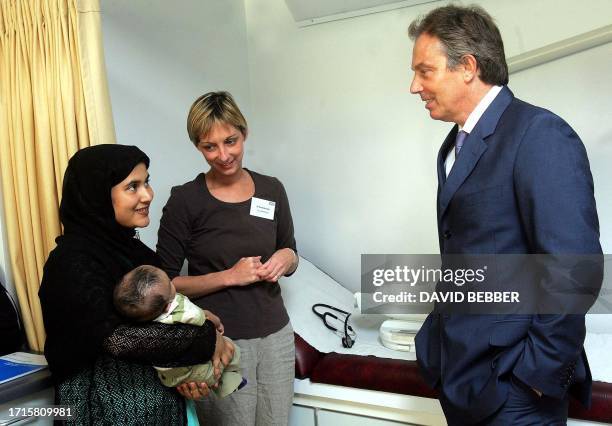Britain's Prime Minister Tony Blair meets a mother with her baby daughter, patients of Dr Sonia Munnelly , at the Amwell Road medical practice in...