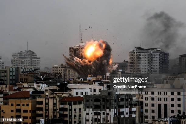 Smoke rises and ball of fire over a buildings in Gaza City on October 9, 2023 during an Israeli air strike.