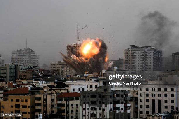 Smoke rises and ball of fire over a buildings in Gaza City on October 9, 2023 during an Israeli air strike.