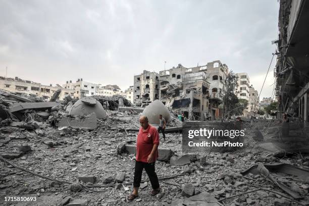 Palestinians man walks infront of the rubble of destroyed buildings and mosque after an Israeli air strikes in Gaza City, on October 9, 2023.