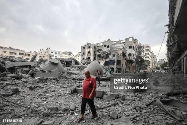 Palestinians man walks infront of the rubble of destroyed buildings and mosque after an Israeli air stike in Gaza City, on October 9, 2023.