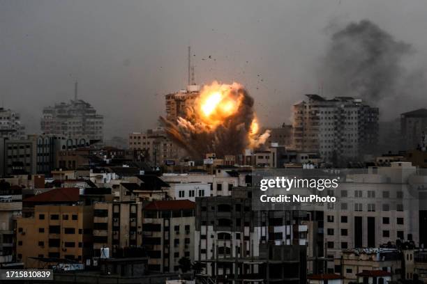 Smoke rises and ball of fire over a buildings in Gaza City on October 9, 2023 during an Israeli air strike.