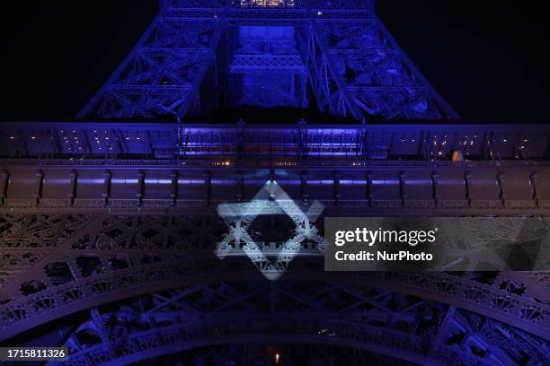 This photograph taken on October 9, 2023 shows the Eiffel Tower illuminated with the Star of David and the colours of national flag of Israel, in...