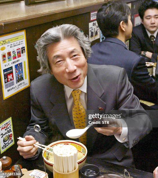 Japanese Prime Minister Junichiro Koizumi smiles as he eats a bowl of Chinese noodles at a small Chinese restaurant near his official residence in...