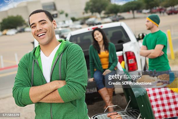 happy football fan tailgating with friends near stadium - football tailgate stock pictures, royalty-free photos & images