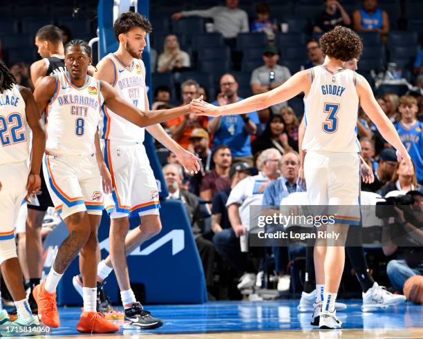 Josh Giddey and Jalen Williams of the Oklahoma City Thunder high five during the game against the San Antonio Spurs on October 9, 2023 at the Paycom...