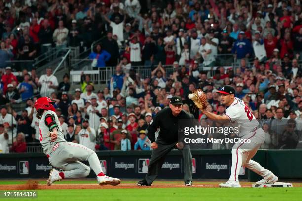 Matt Olson of the Atlanta Braves tags out Bryce Harper of the Philadelphia Phillies at first base for the final out in Game 2 of the Division Series...