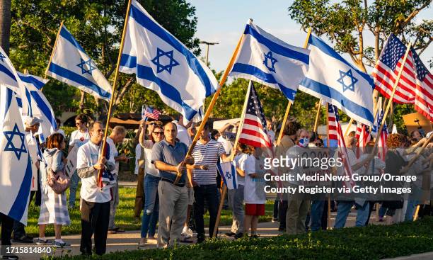 Members of the Orange County Jewish community and others gather at the intersection of Culver Drive and Alton Parkway in Irvine on Monday, October 9,...