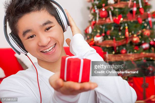 smiling male listening to headphone at christmas - christmas music listen stock pictures, royalty-free photos & images