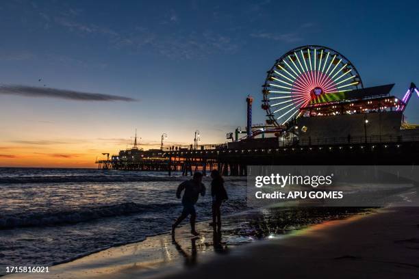 The Santa Monica Pier is pictured as the sun sets in Santa Monica, California on October 9, 2023.