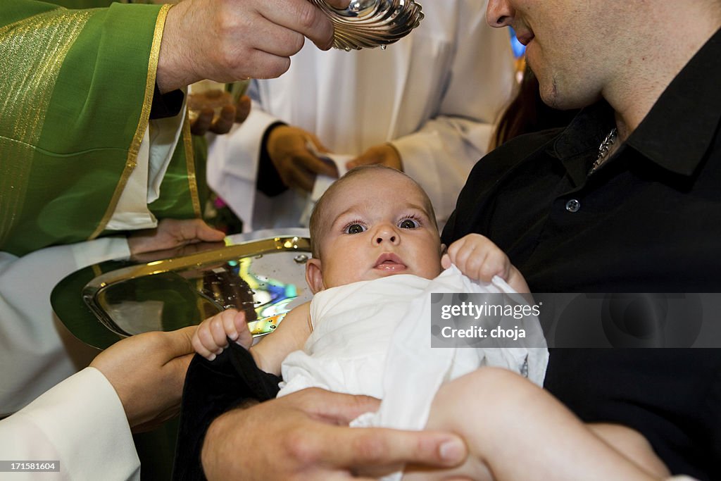 In church.Priest è baptizing piccolo bambino.