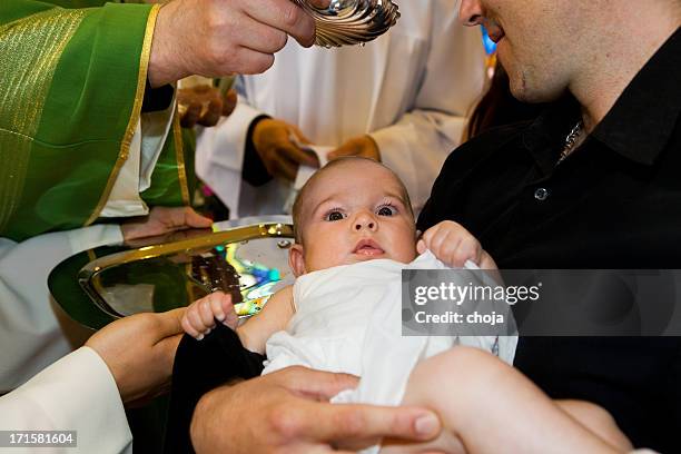 in church...priest is baptizing little baby. - baptism baby stock pictures, royalty-free photos & images