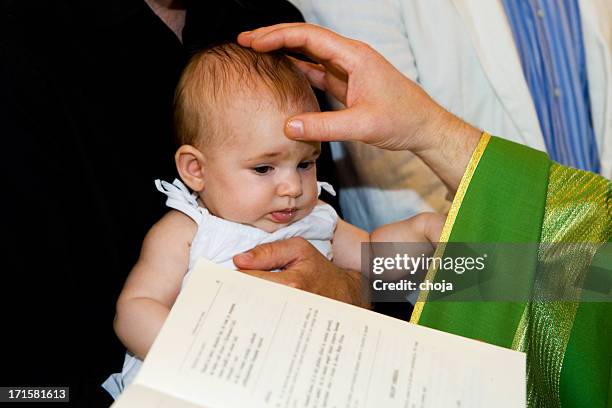 priest is baptizing little baby in church. - dopen stockfoto's en -beelden
