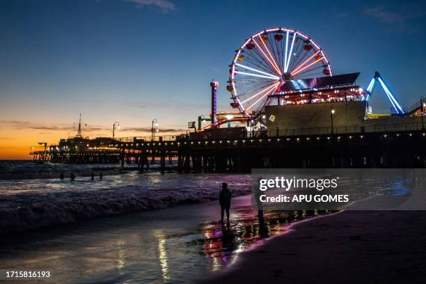 The Santa Monica Pier is pictured as the sun sets in Santa Monica, California on October 9, 2023.