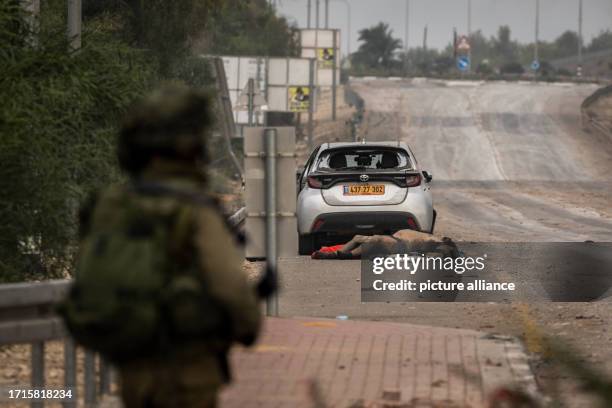 October 2023, Israel, Sa'ad: A body lies on a side road as Israeli forces patrol regions along the Israeli-Gaza border while fighting between Israeli...