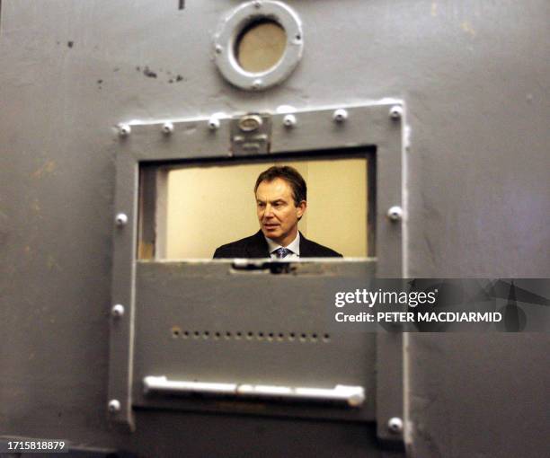 Britain's Prime Minister Tony Blair stands in a cell during a visit to Slough police station near London, 25 November 2004. The British government...