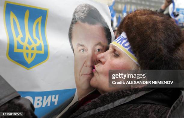Supporter of Ukraine's pro-Russia Prime Minister and the presidential candidate Viktor Yanukovich kisses his portrait during A rally in downtown...