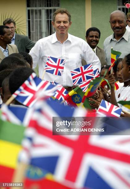 British Minister Tony Blair watches over children as they wave the flags of Ethipia and Great Britain while visiting The Jerusalem Children and...