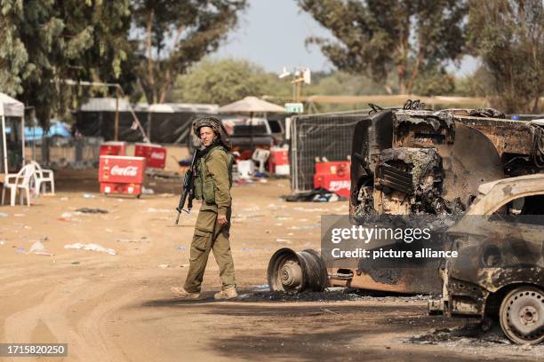 October 2023, Israel, Re'im: An Israeli solider stands at the grounds of the Supernova electronic music festival after Saturday's deadly attack by...